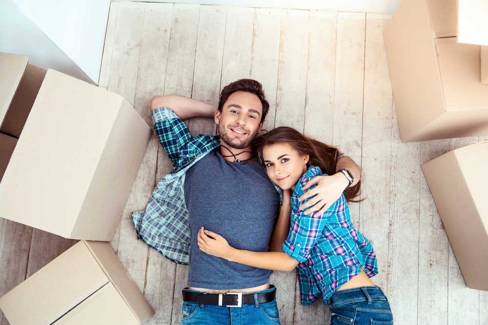 happy couple lying on the ground with empty boxes around